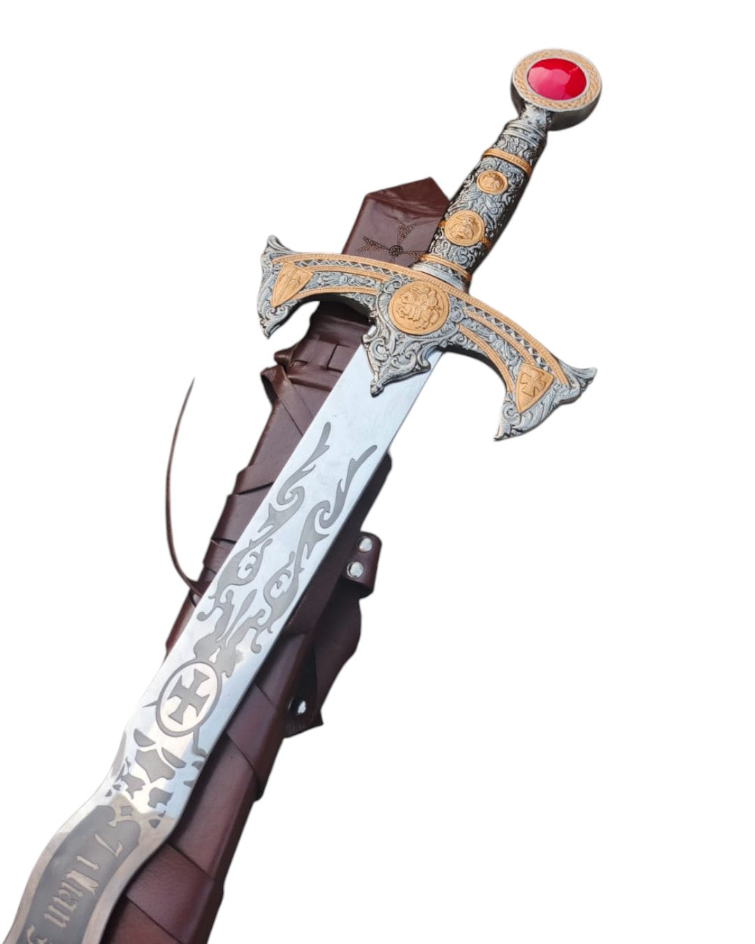 Decorative sword with intricate designs and a red gem on a white background