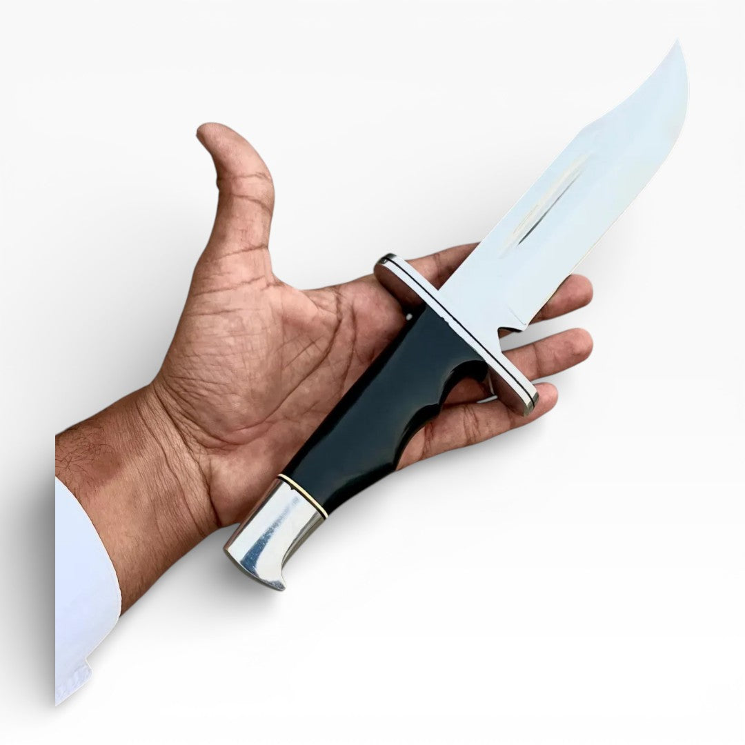 Hand holding a knife with a silver blade and black handle on a white background