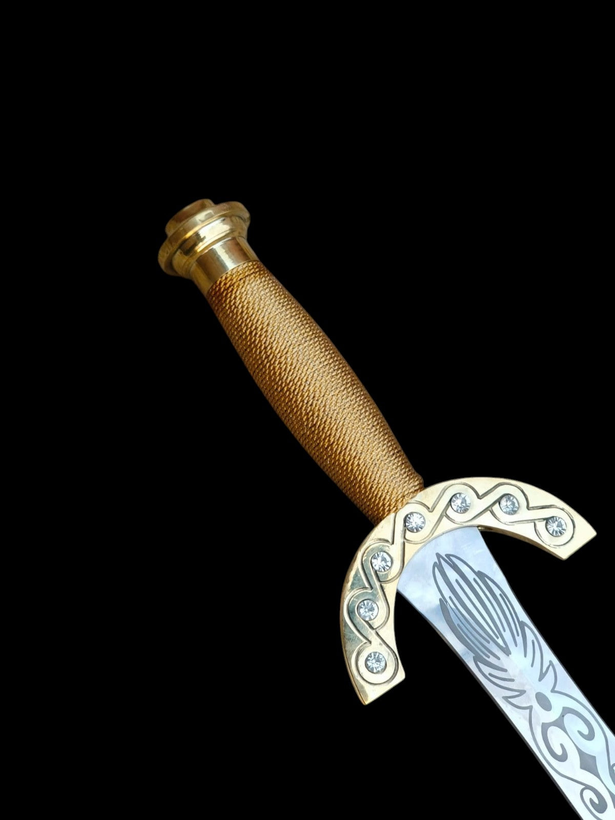 Decorative dagger with gold handle and silver blade on a black background