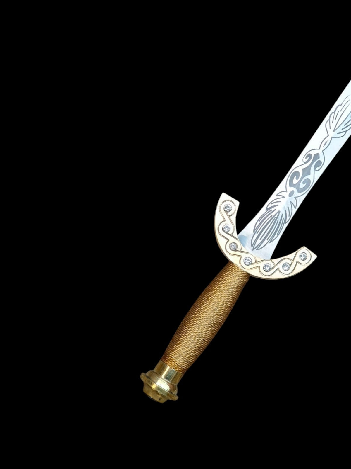 Decorative sword with gold handle and intricate blade design on a black background